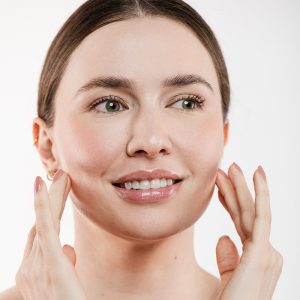 Mujer sonriendo con los dedos en el rostro